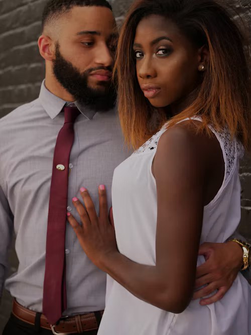 A husband and wife standing close together, dressed formally